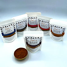 Load image into Gallery viewer, Image of the full range of Sashi's masalas. 6 packets of 50g masalas with Biryani in front.