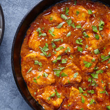 Load image into Gallery viewer, Image of a dish of chicken curry partially covered with chopped coriander
